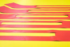 A photo of some cut fabric pieces laying on the machine table.