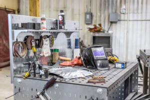A table with a bunch of welding equipment on top of it.