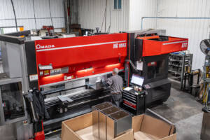 An aerial photo of an employee forming sheet metal at a CNC Press Brake Machine.