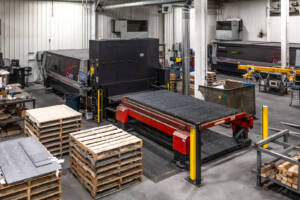 A photo of a large metal laser cutting machine at Yoder Industries.