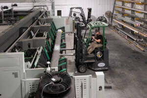 Forklift taking metal tubes off of Laser Tube Cutting Machine.