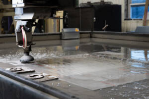 Big Water Jet Cutting system cutting custom metal components.
