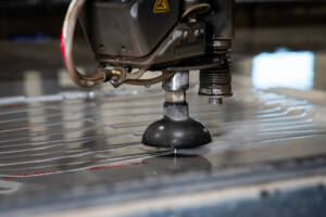 A closeup shot of a water jet machine cutting metal.