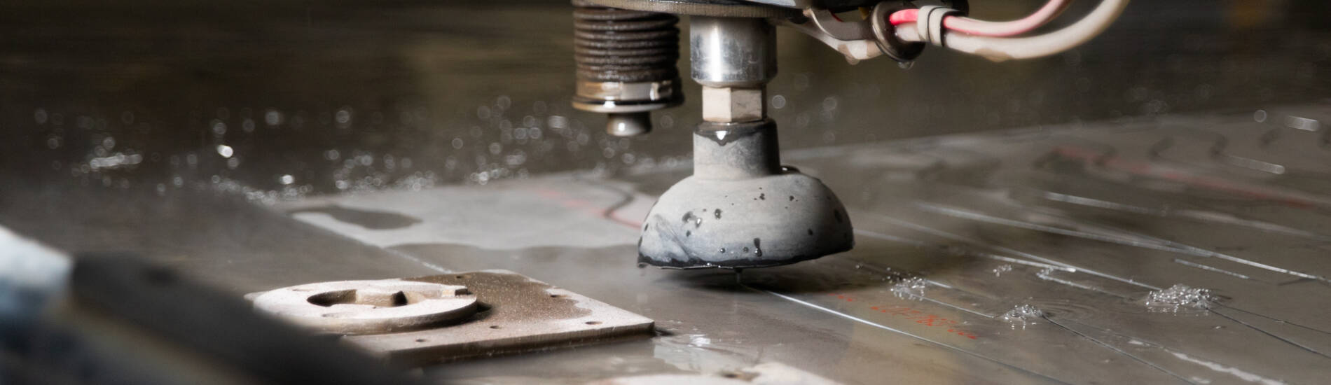 A closeup photo of a water jet machine cutting metal at a metal shop in Lancaster PA.